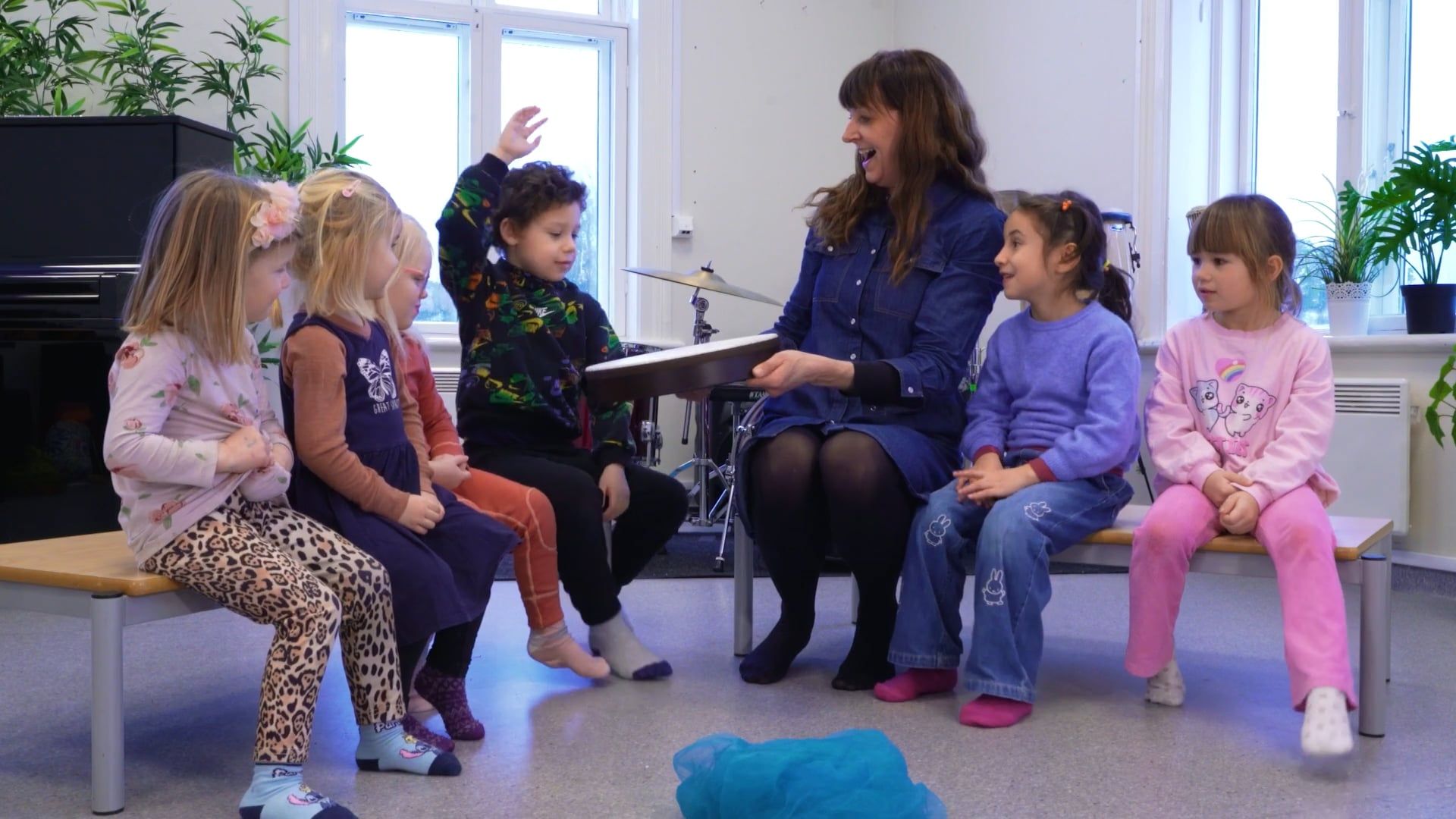 Barn og en voksen sitter sammen og synger