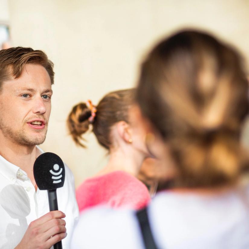 Bilde av filmfotograf Peder M Egge som holder en mikrofon og blir intervjuet