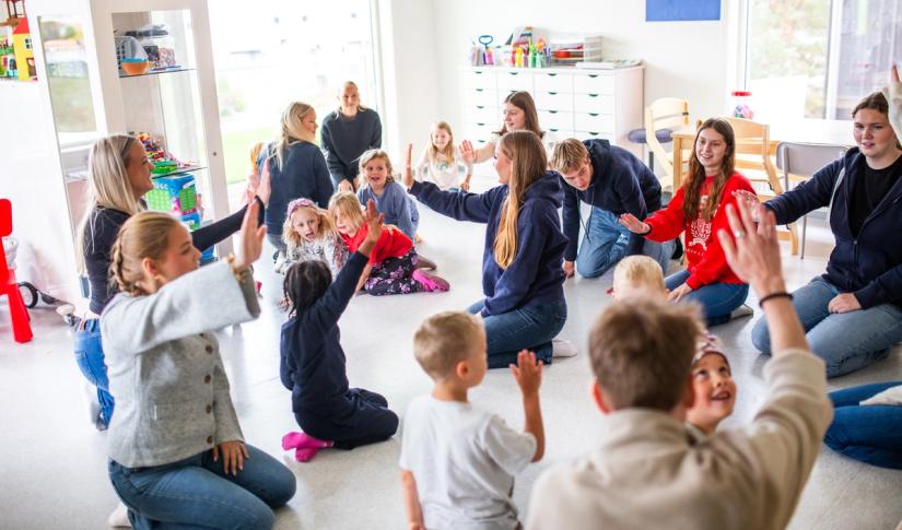 Elever ved Barne og ungdomsarbeiderfag (BUA) gjennomfører en sang og musikksamling i en barnehage.
