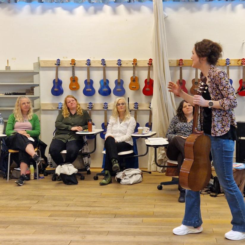 Vi ser kursleder Lise Lotte Berg Ågedal med en gitar i hånden