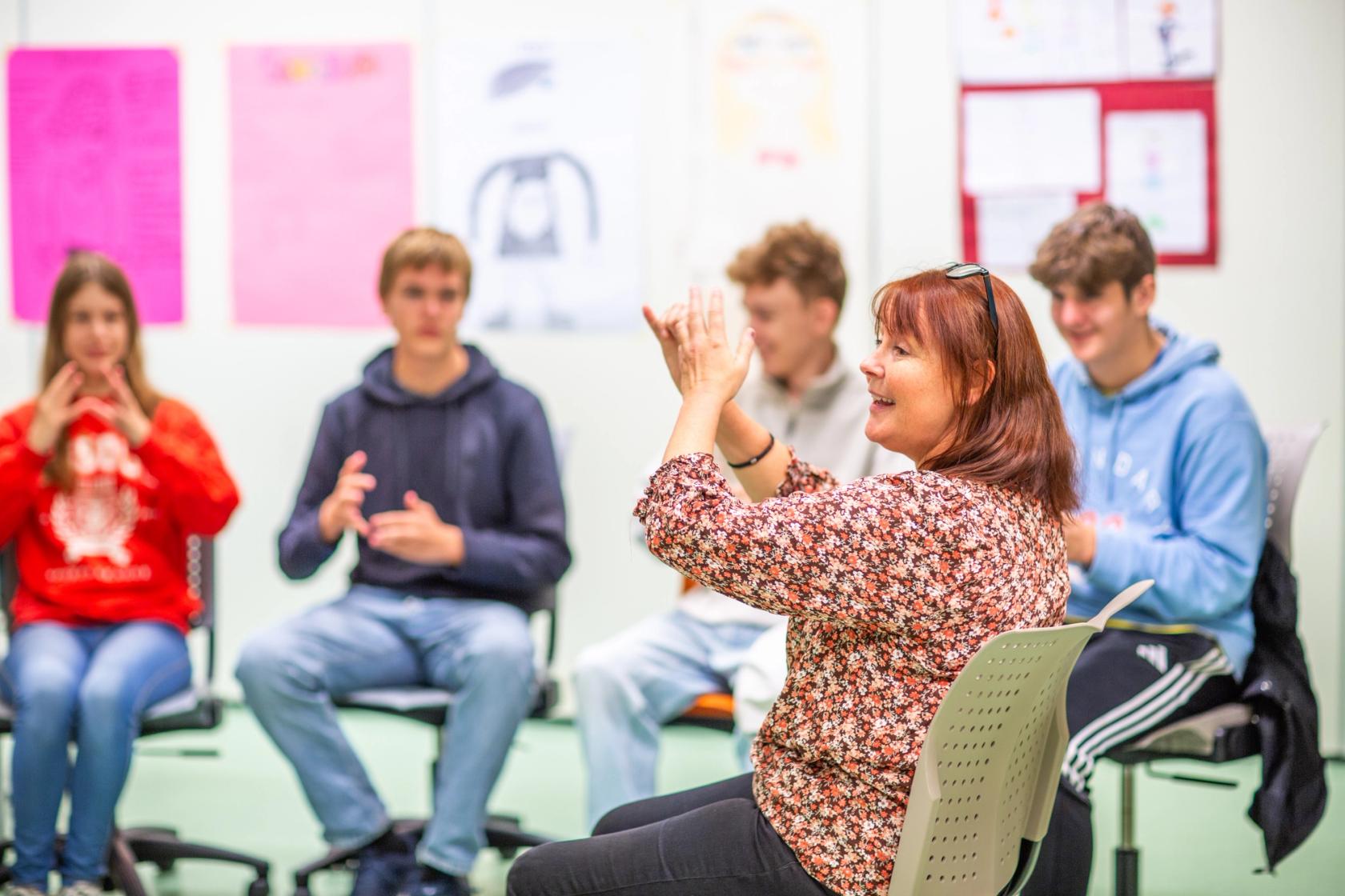 En lærer instruerer en fingerregle til vgs-elever som hermer. Foto: Krafttak for sang