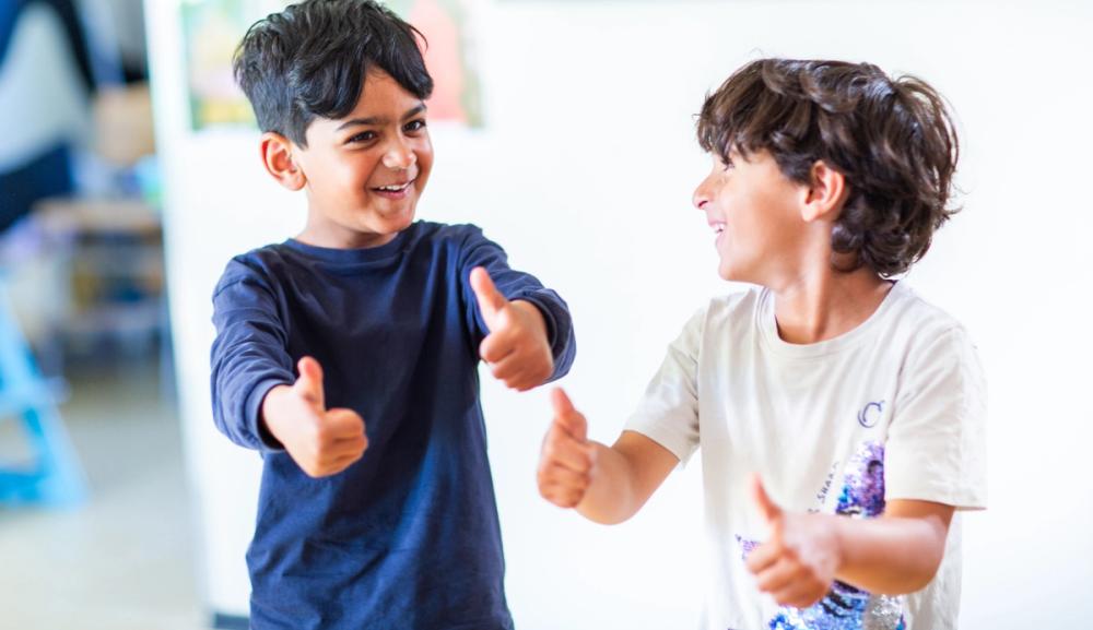 Bilde av to gutter som viser frem tomlene sine