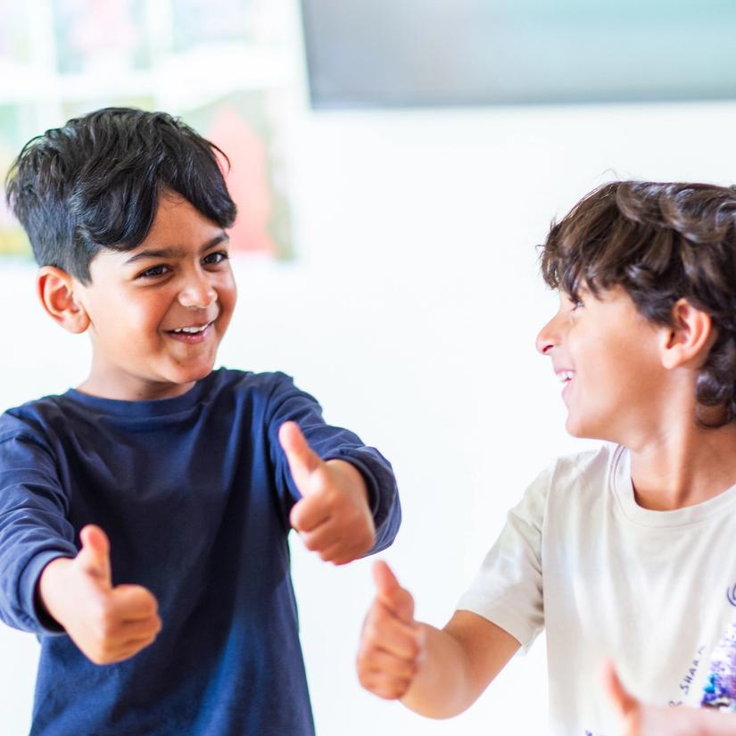 Bilde av to glade gutter som synger en sang om tomlene