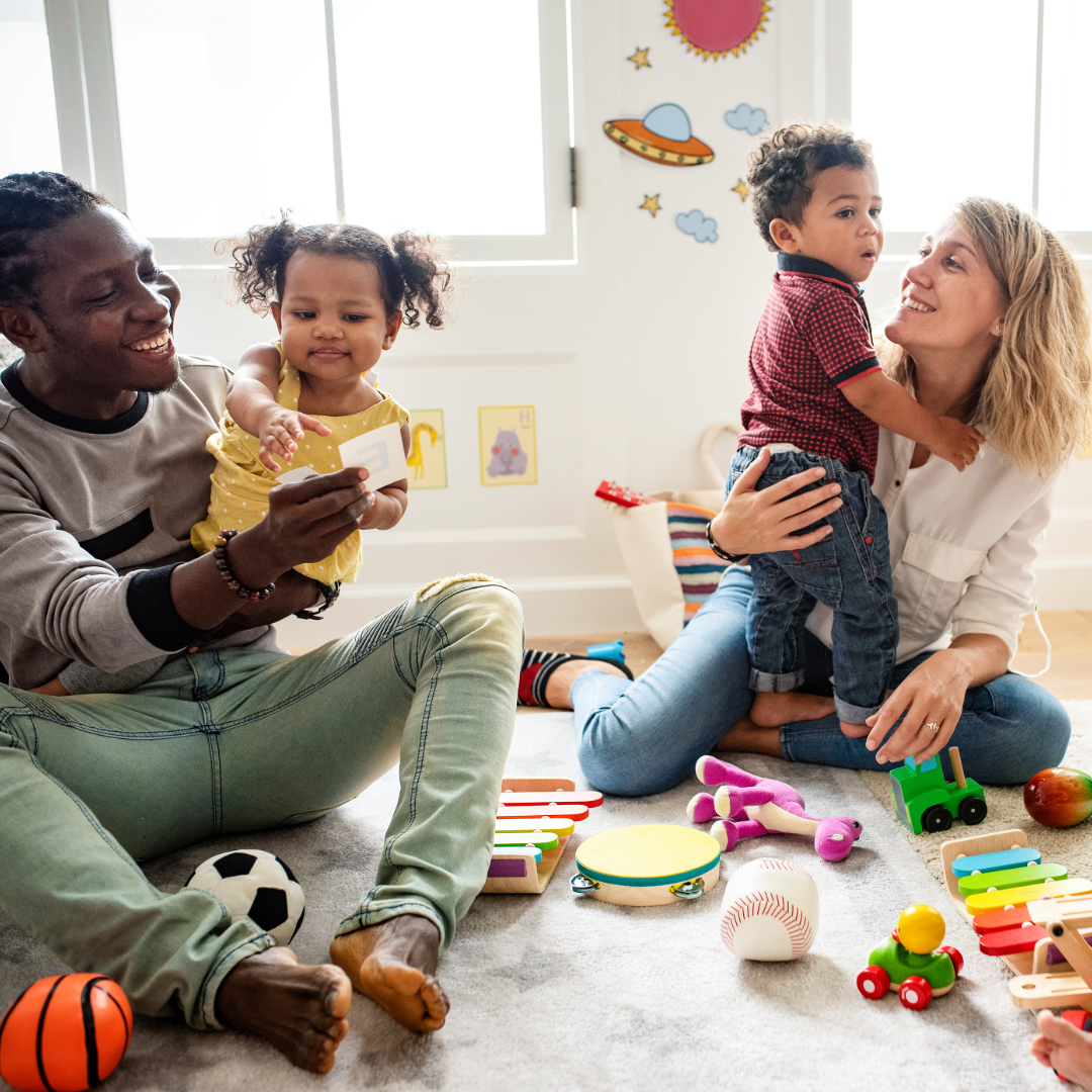 Bilde av en mor og en far med sine barn i en barnehage