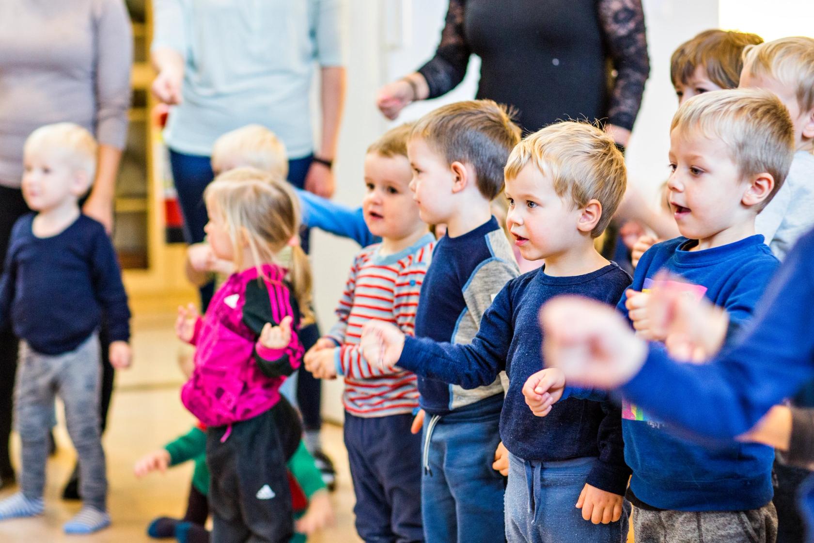 Bilde av barn og ansatte i samlingsstund i en Syngende barnehage