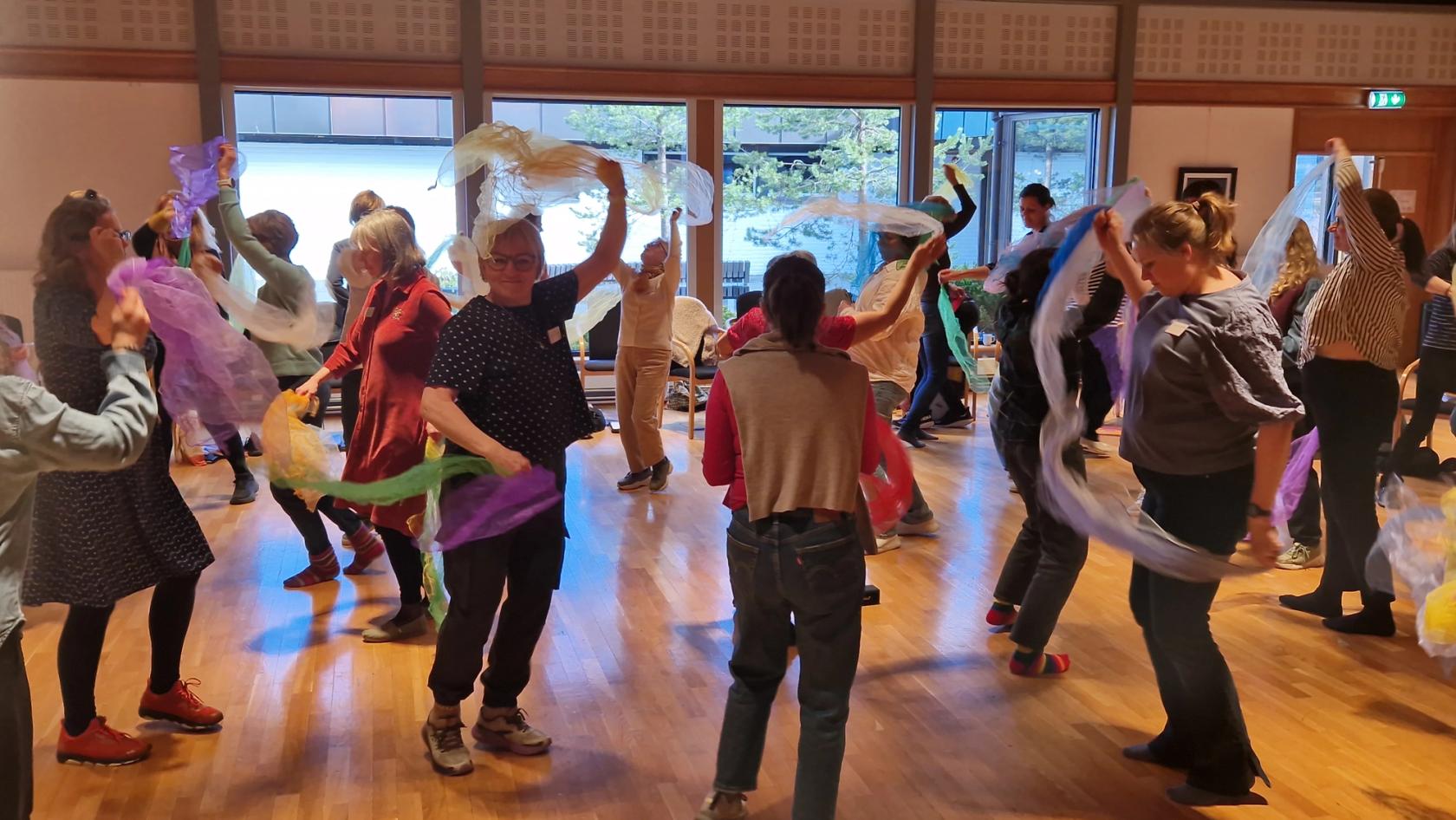 Bilde av voksne på kurs som danser med sjal.