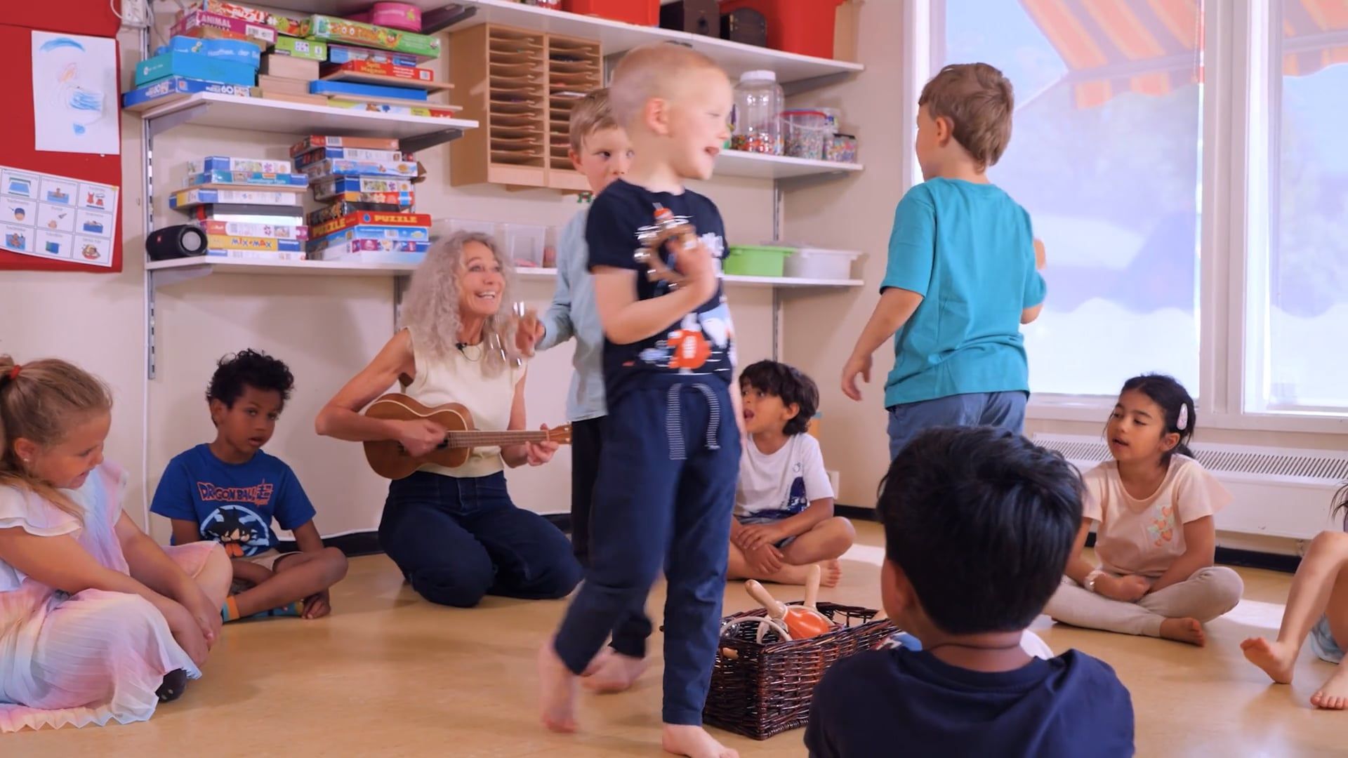 Bilde av Gisela som spiller ukulele sammen med barn