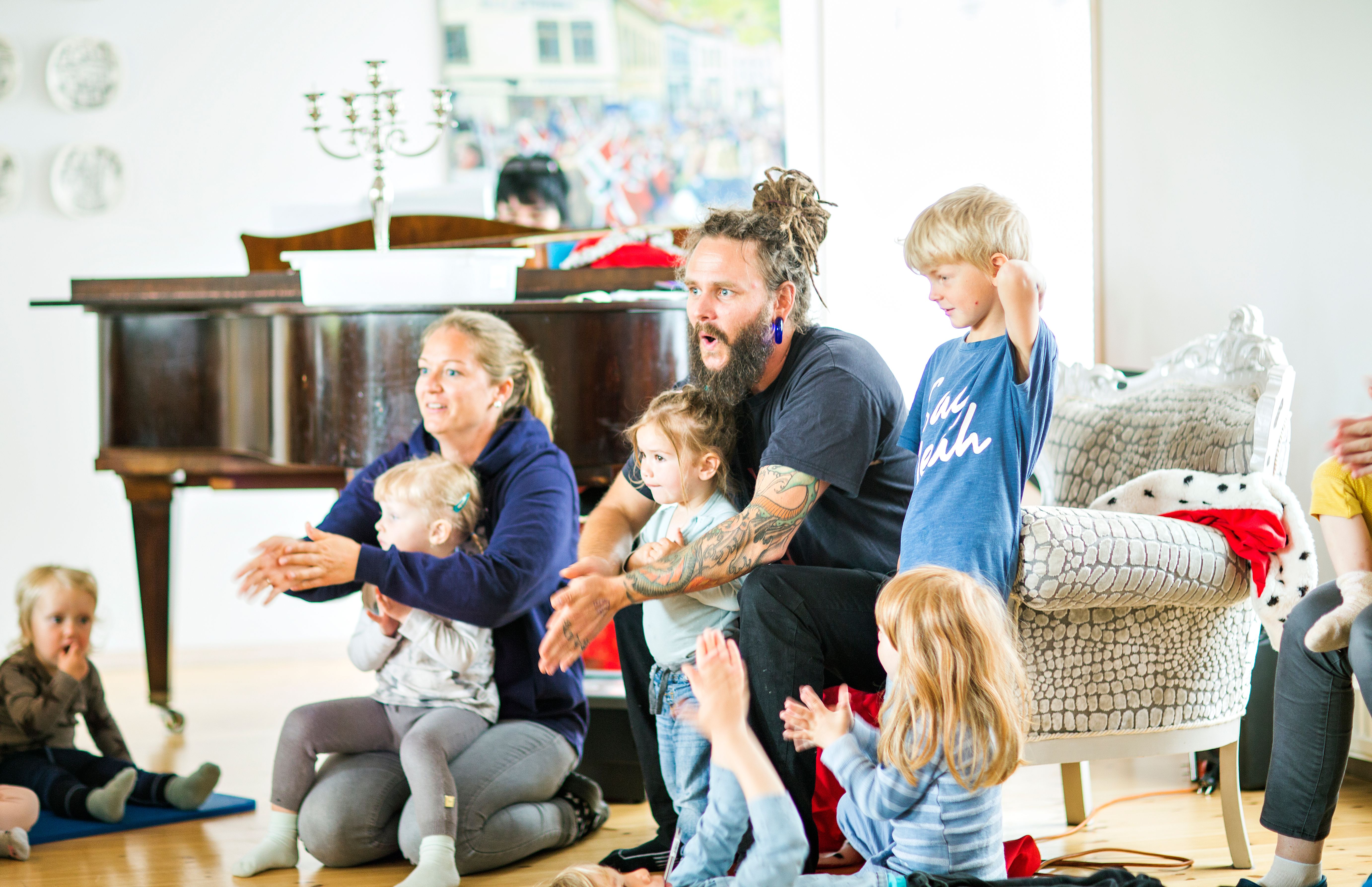 Bilde av samlingsstund i en Syngende barnehage, med ansatte og barn sammen som synger og klapper. Foto: Krafttak for sang