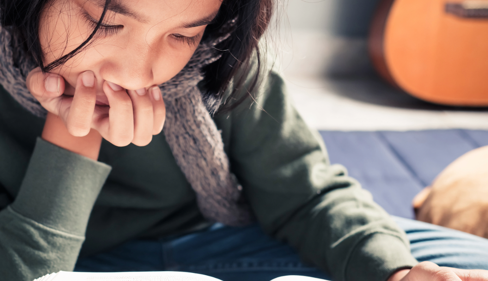 Bilde av en jente som leser en bok. Foto: Adobe express