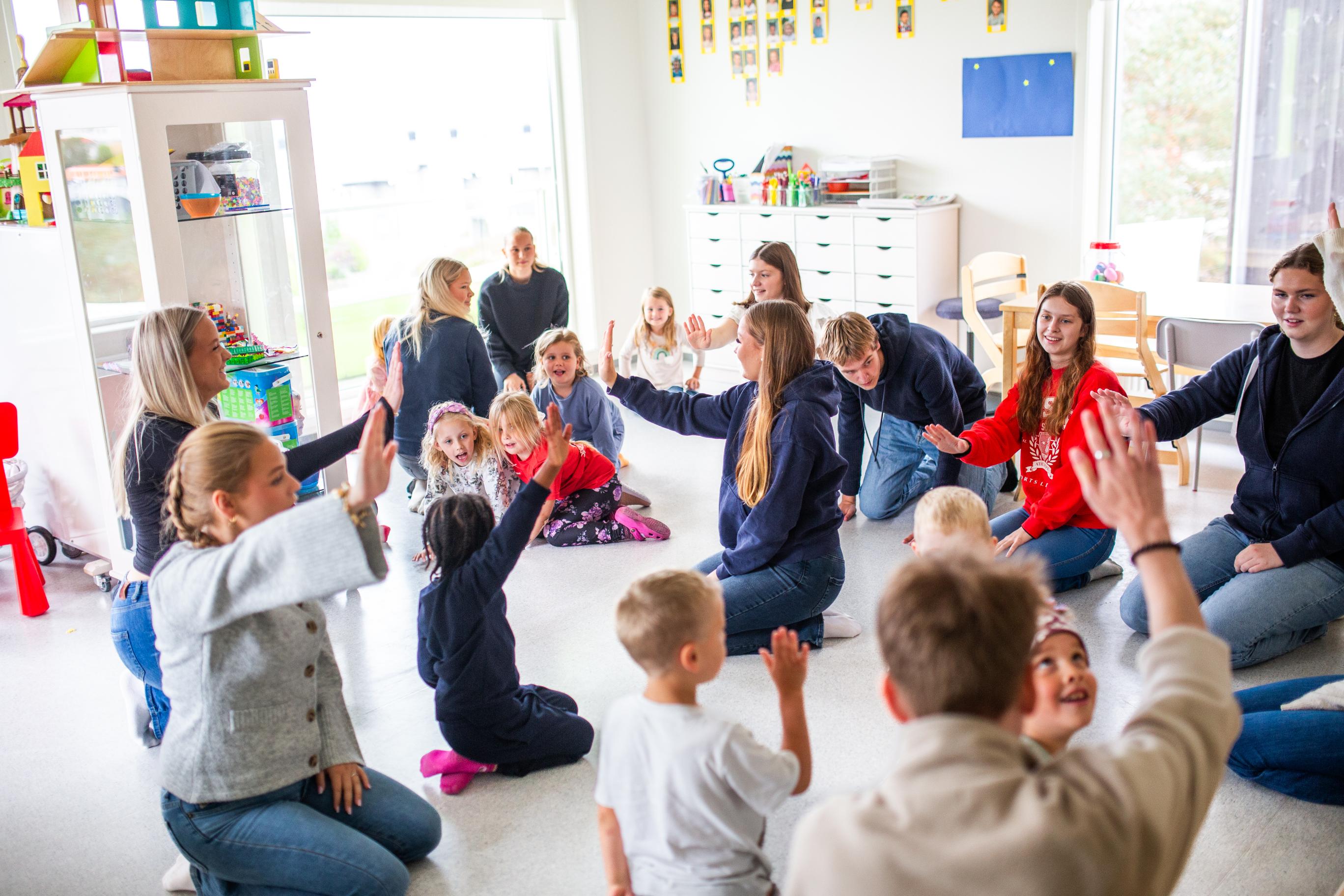 Elever og barnehagebarn synger og danser sammen. Knarvik vgs.