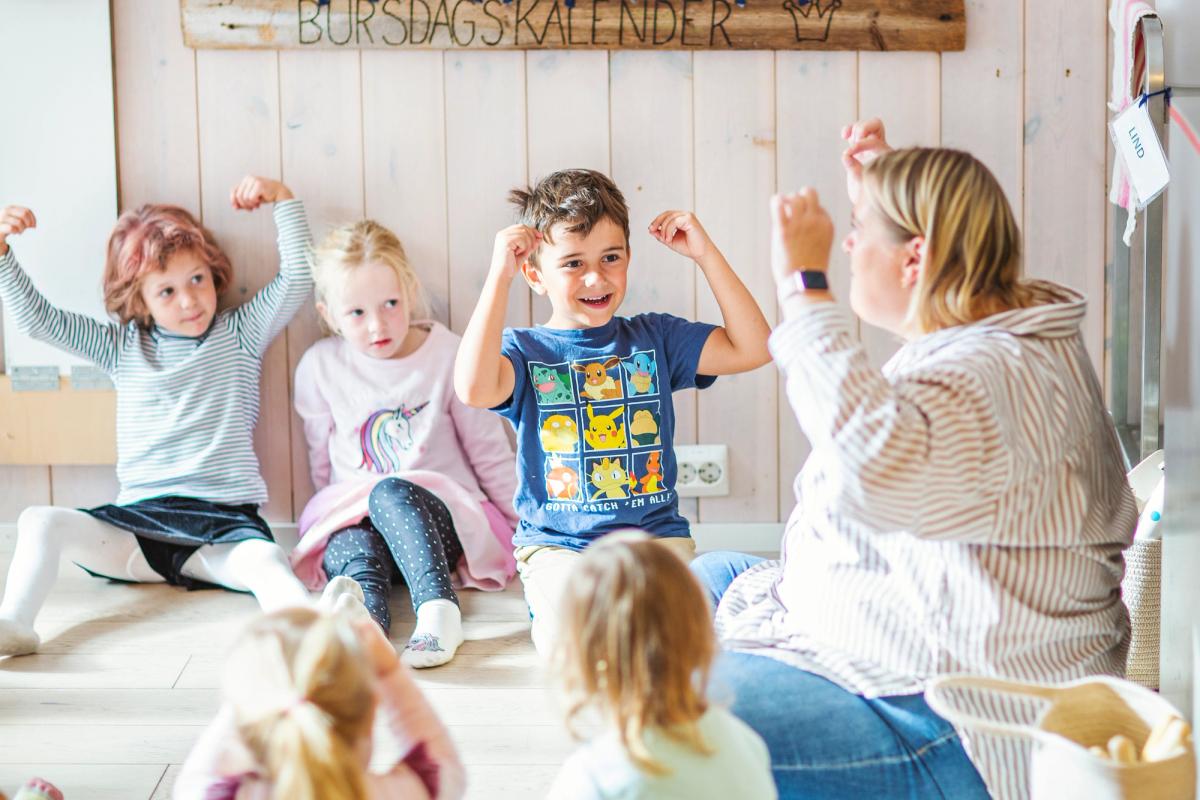 Barn som synger av glede med en barnehageansatt