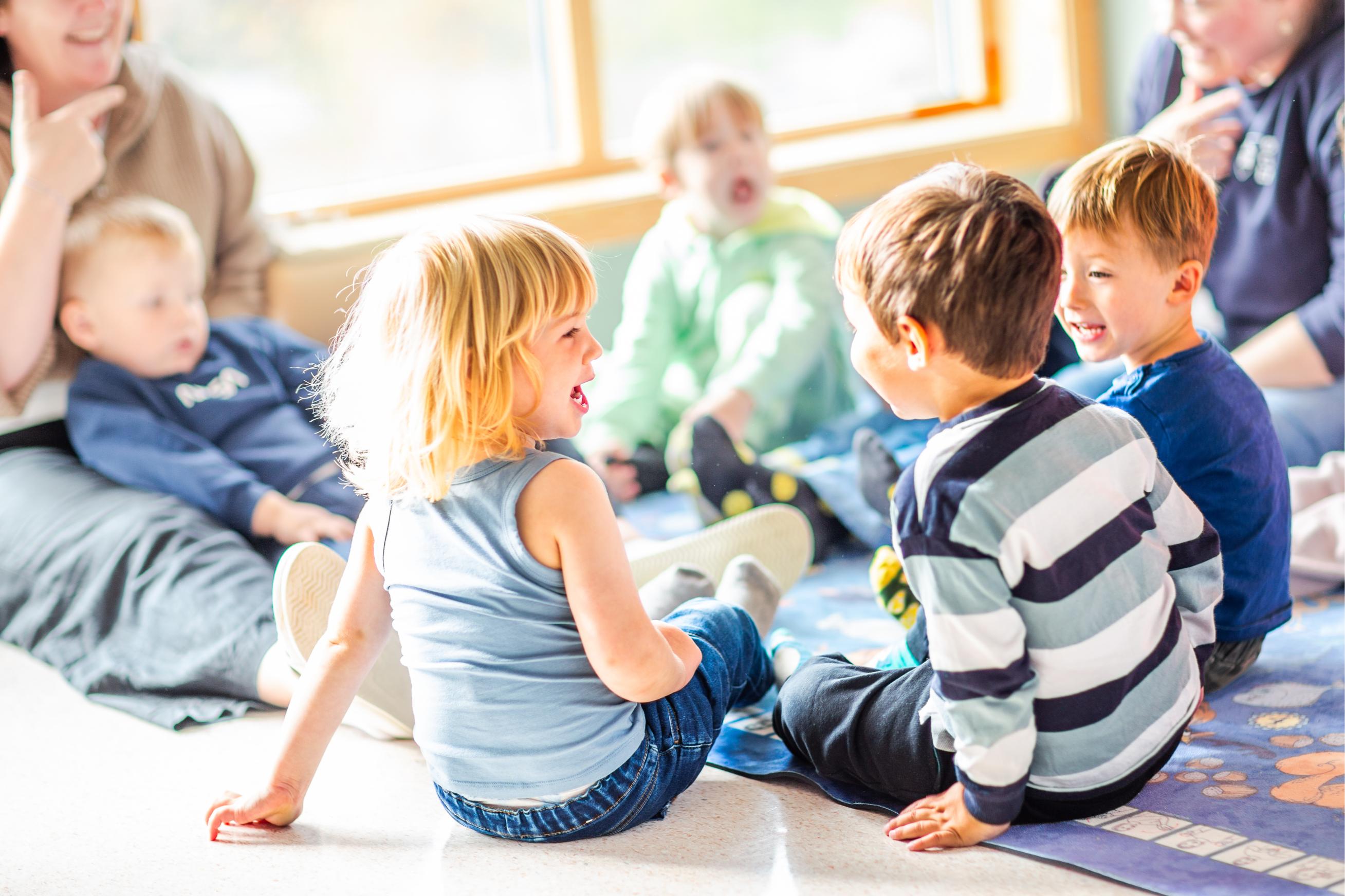 Barn synger sammen og ler i samlingsstund.