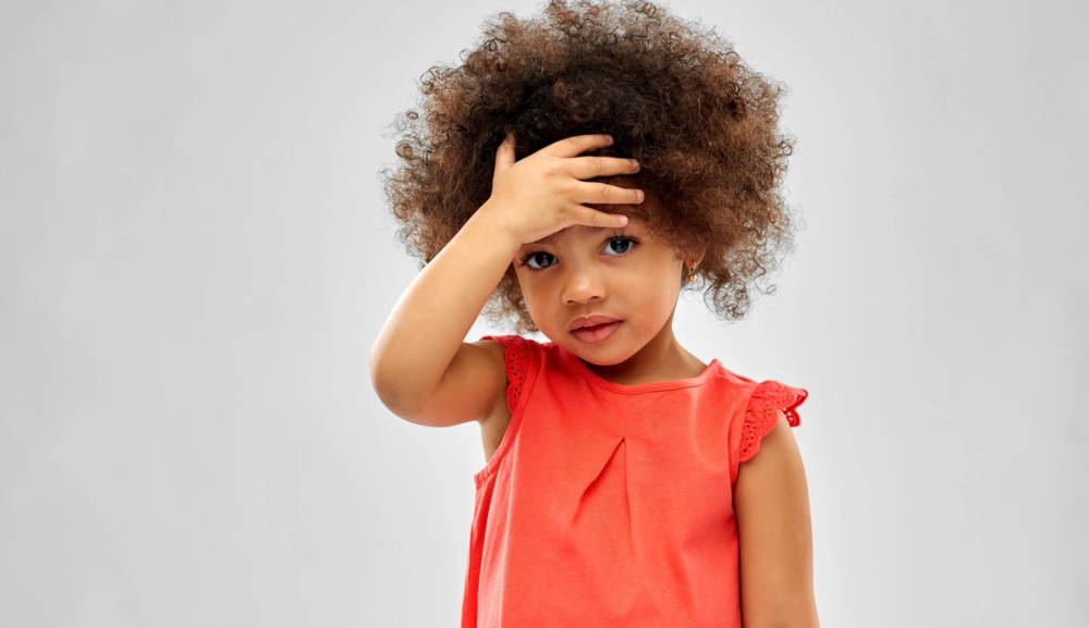 Bilde av et barn som holder hånden på pannen
