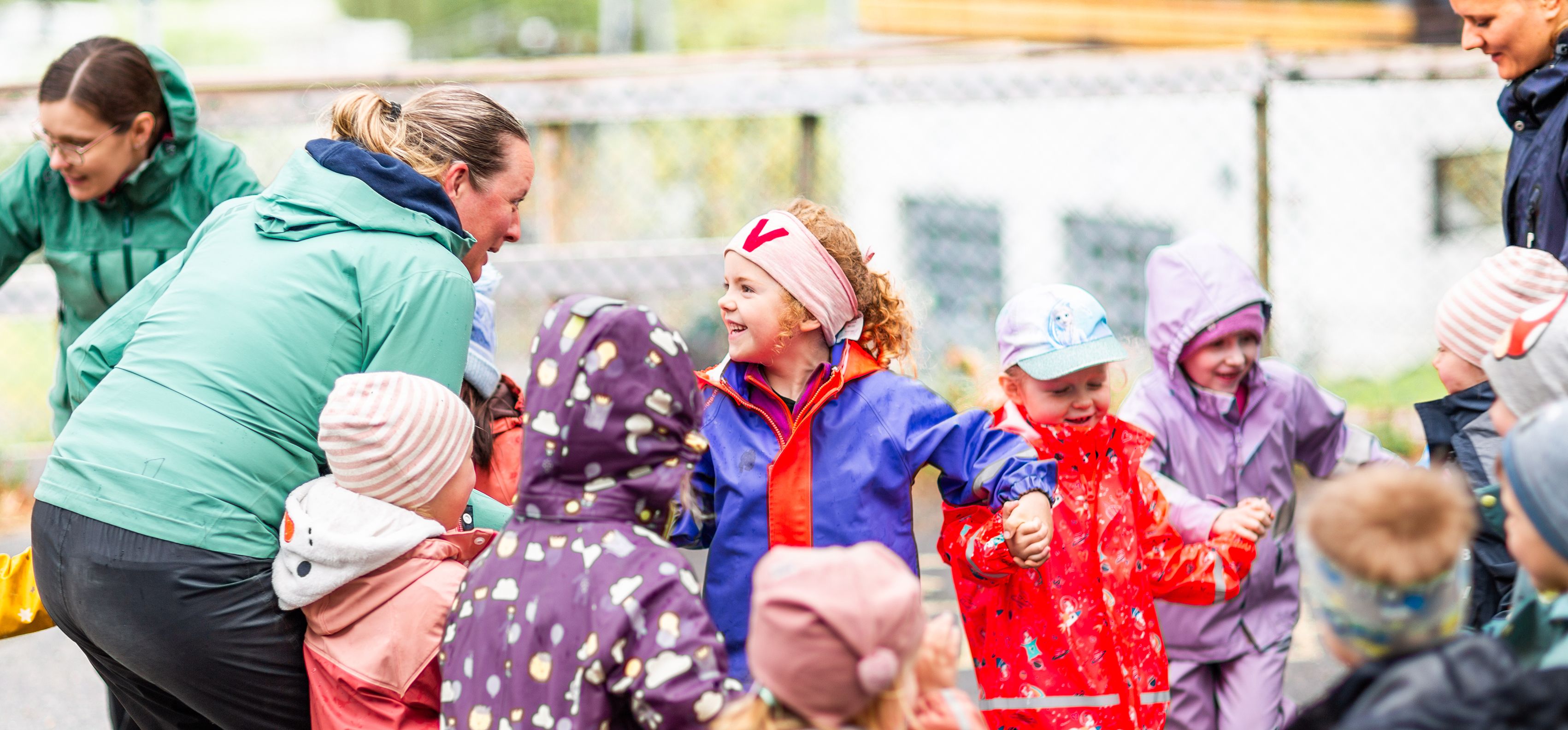 Barn fra en Syngende barnehage synger med en ansatt som sitter i midten og leder an. Foto: Krafttak for sang