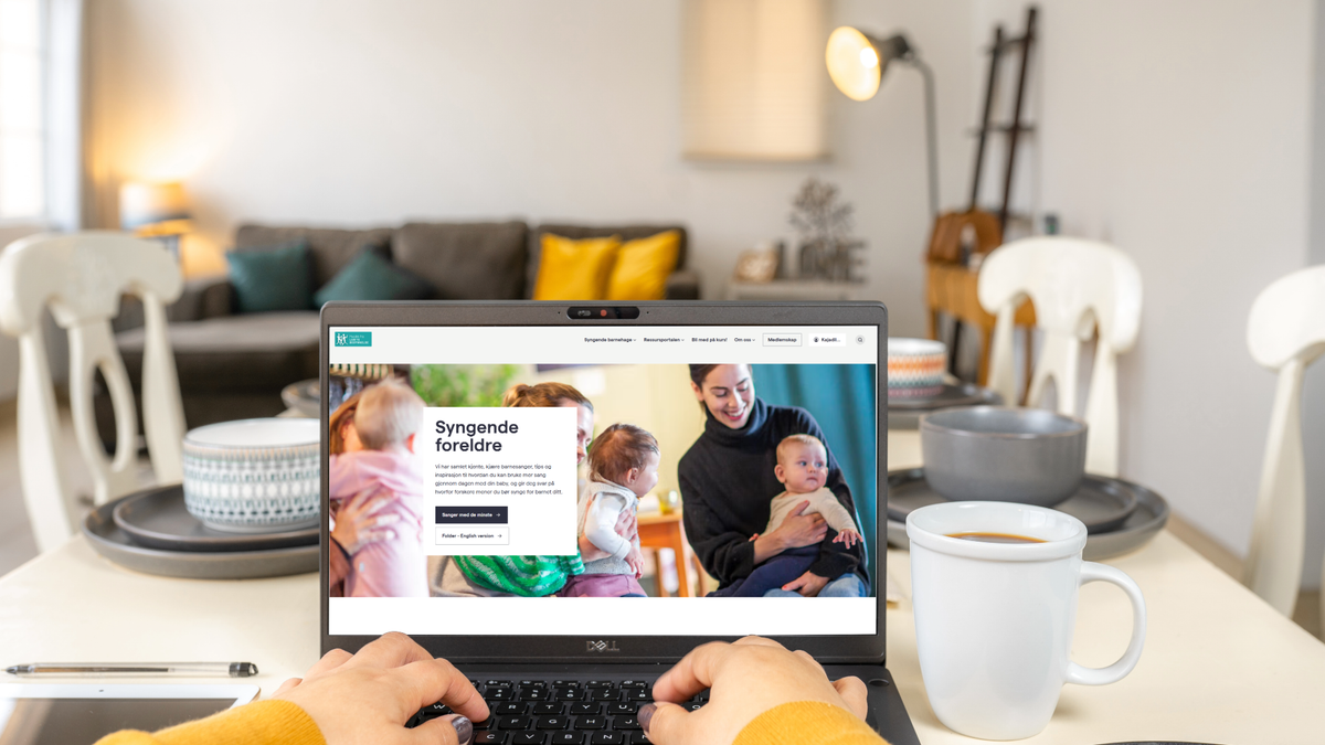 Bilde av et barn som sitter på fanget til en eldre dame. 