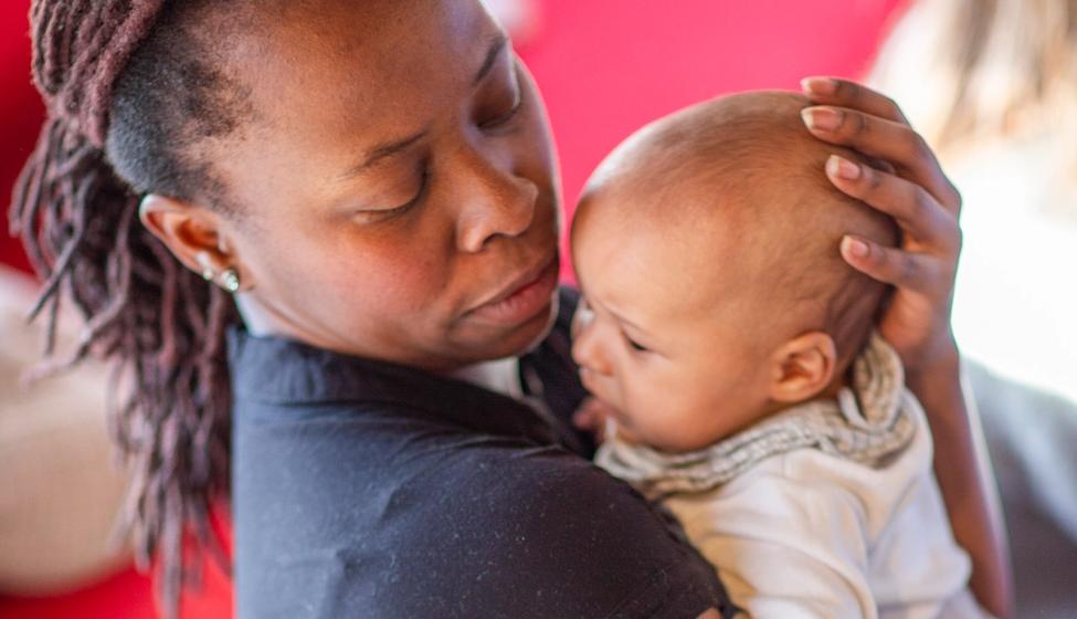 Bilde av en mor som holder sitt barn i armene