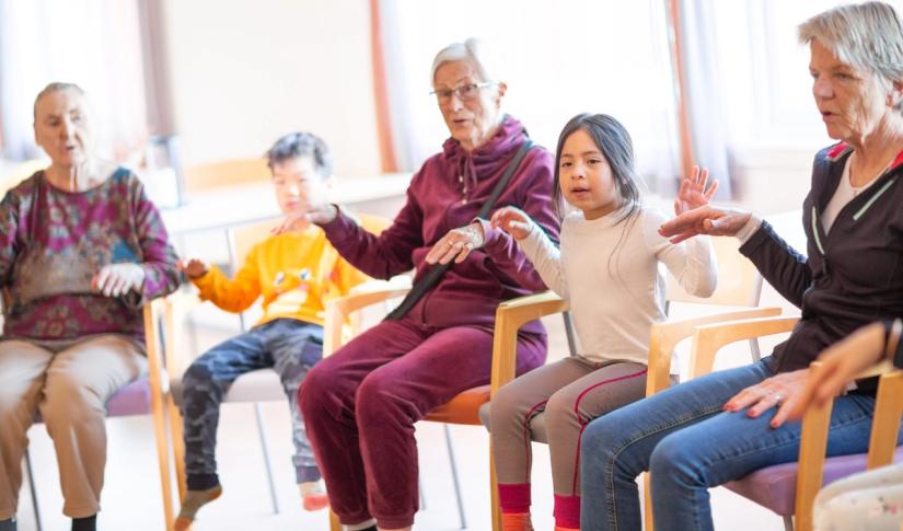 Barn og eldre synger sammen på institusjon