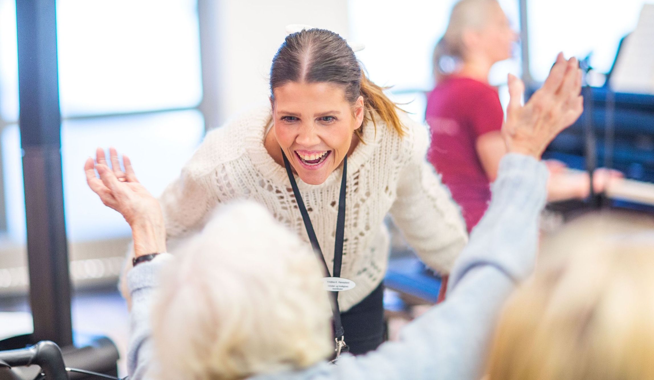 Bilde av en aktivitør som synger sammen med en beboer på en eldreinstitusjon