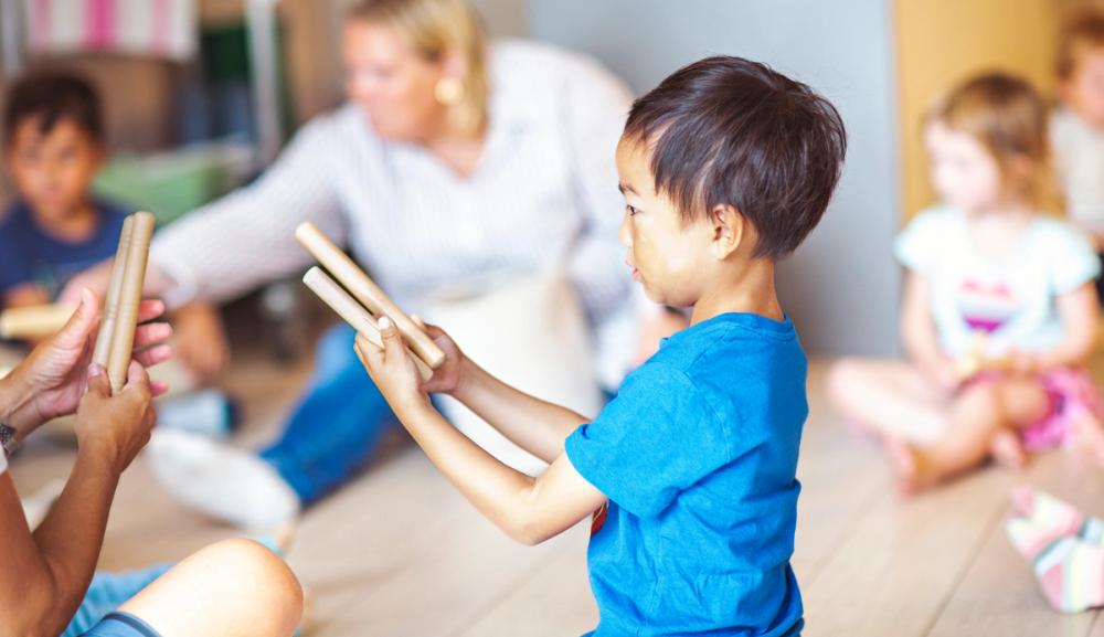 Bildet viser barn i barnehage som spiller med rytmepinner. Foto: Krafttak for sang