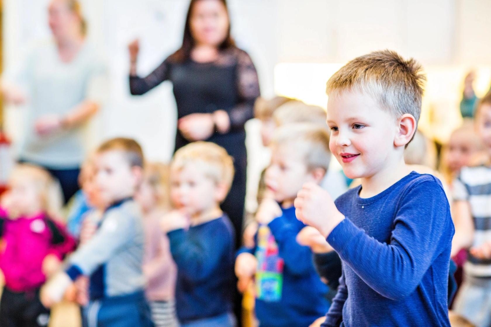 Barn som synger sammen med ansatte i en barnehage. Foto: Krafttak for sang
