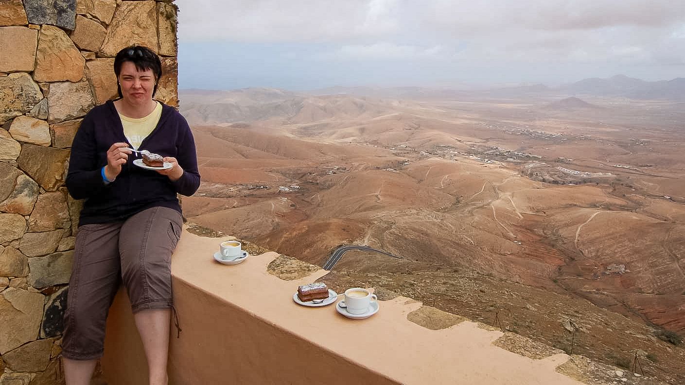 Aussichtspunkt Mirador Morro Velosa auf Fuerteventura, Birgit mit Kaffee und Blick über die Berglandschaft