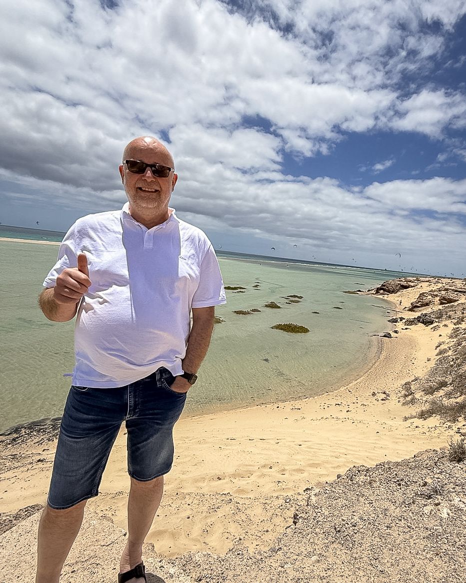Frank an der Küste von Fuerteventura mit Sand, Meer und bewölktem Himmel
