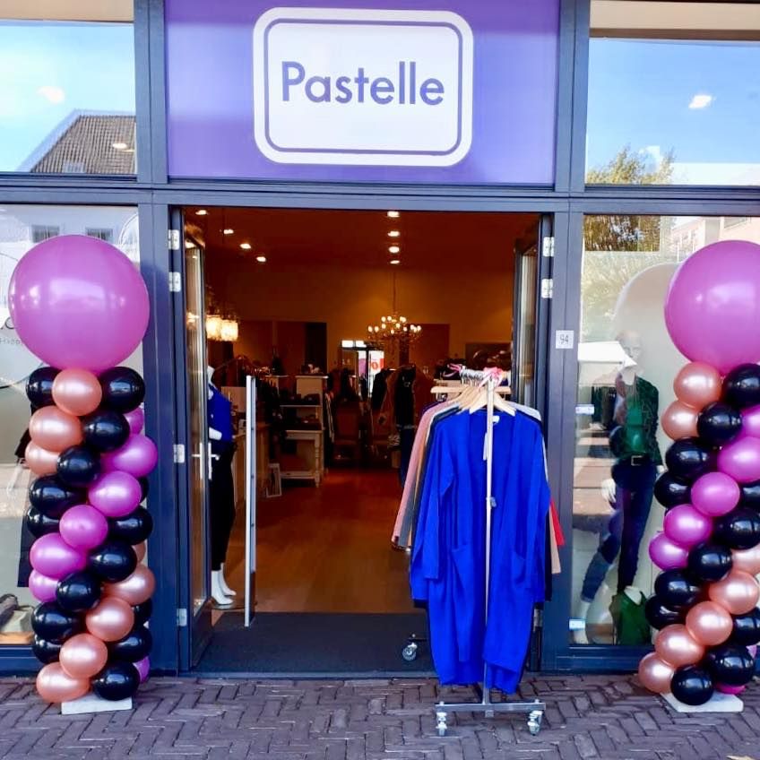 Ballonpilaren in roze en zwart bij de opening van een winkel
