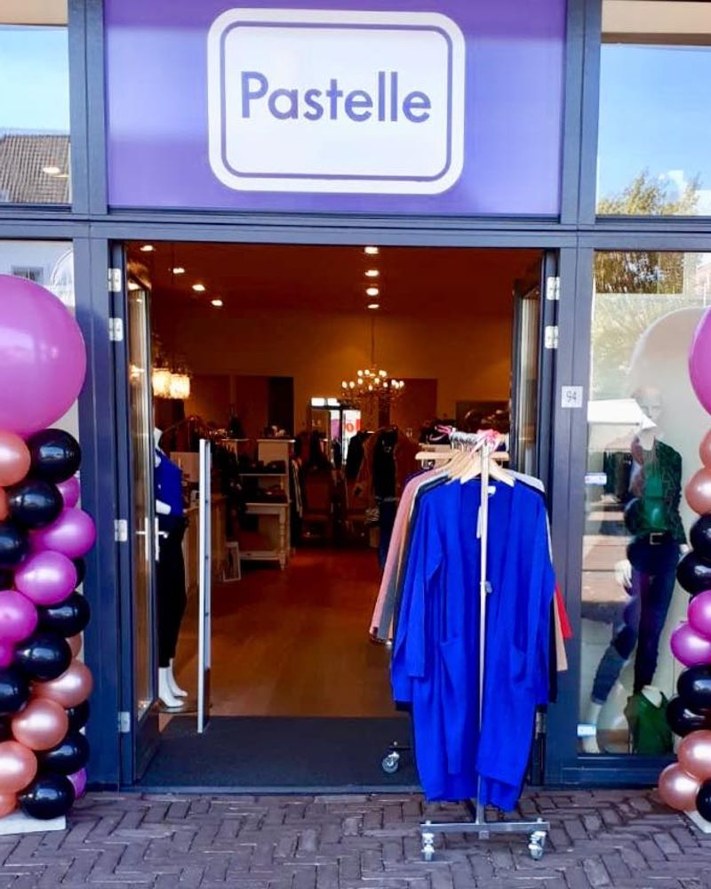 Ballonpilaren in roze en zwart bij de opening van een winkel