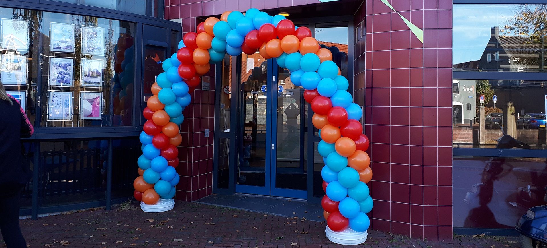 Kleurrijke ballonboog over de entree van een kantoor