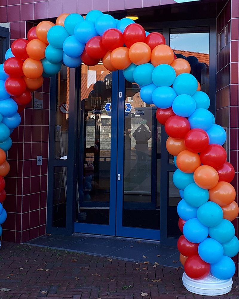 Kleurrijke ballonboog over de entree van een kantoor