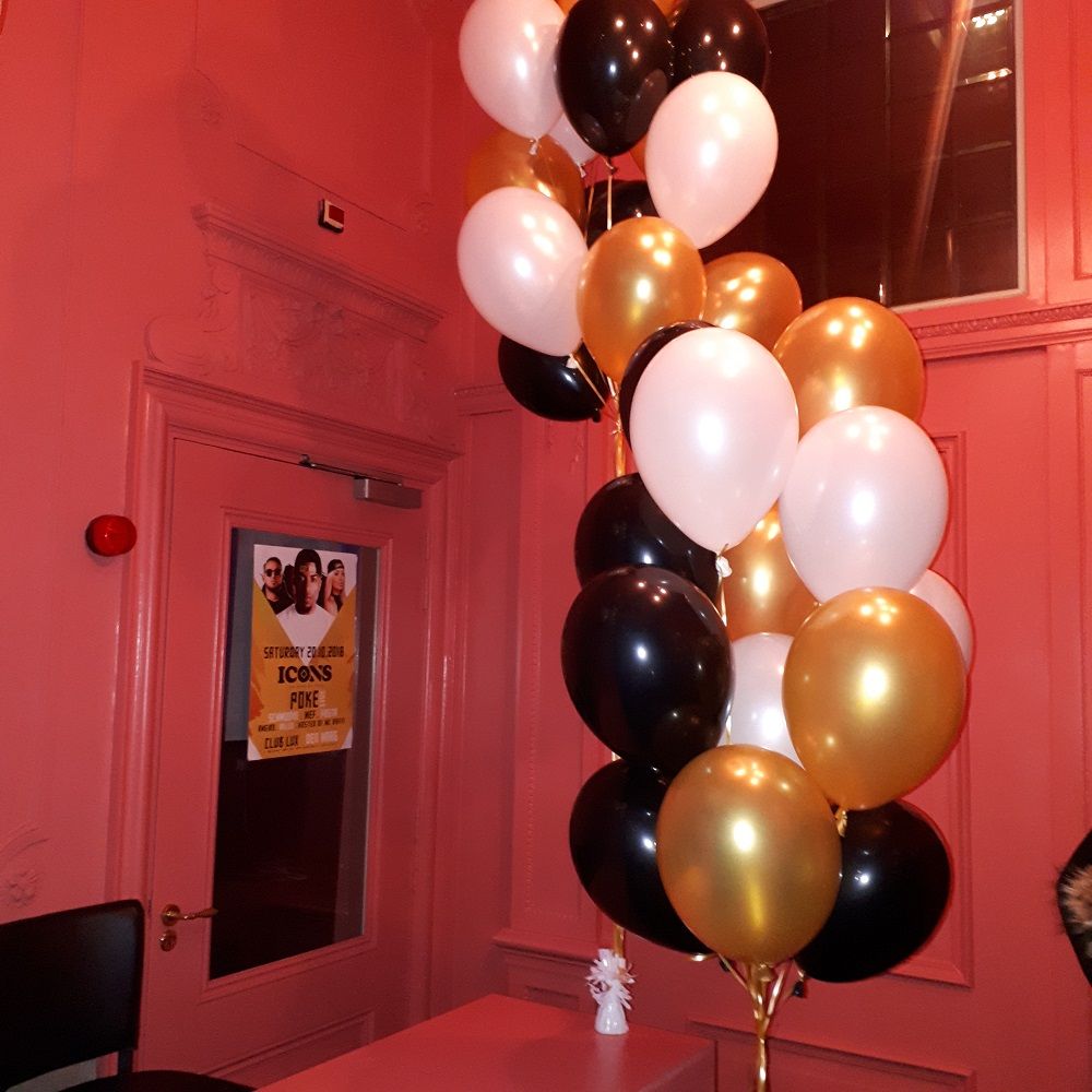 Heliumtrossen in zwart, goud en wit op een avondfeest