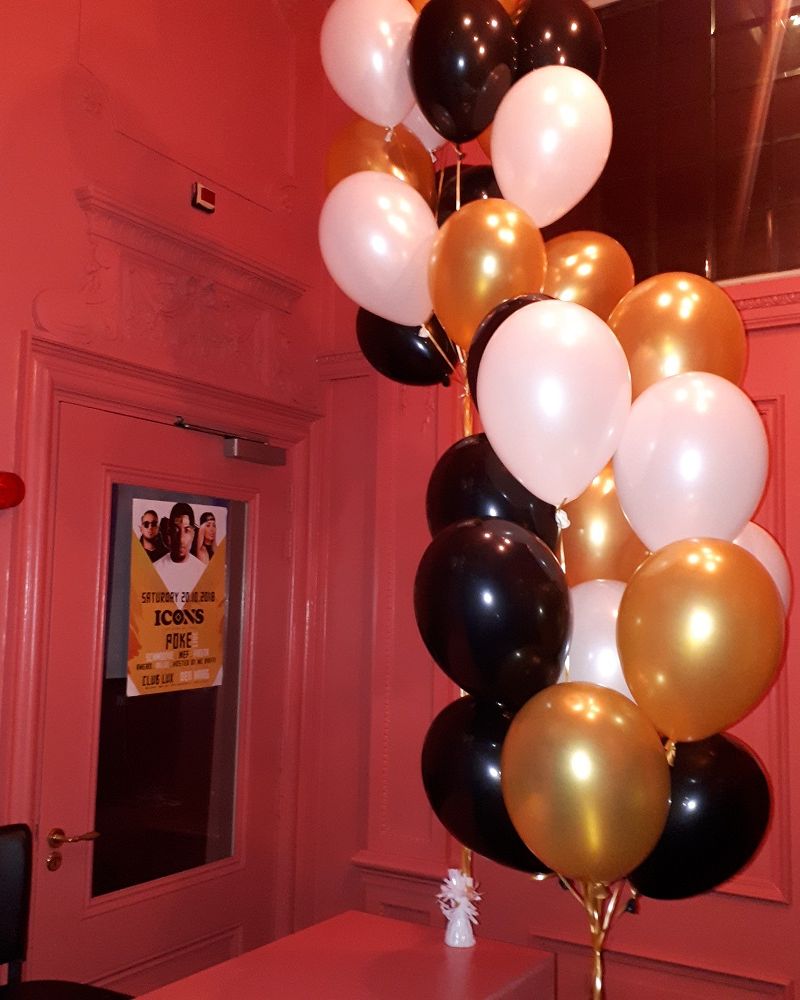 Heliumtrossen in zwart, goud en wit op een avondfeest