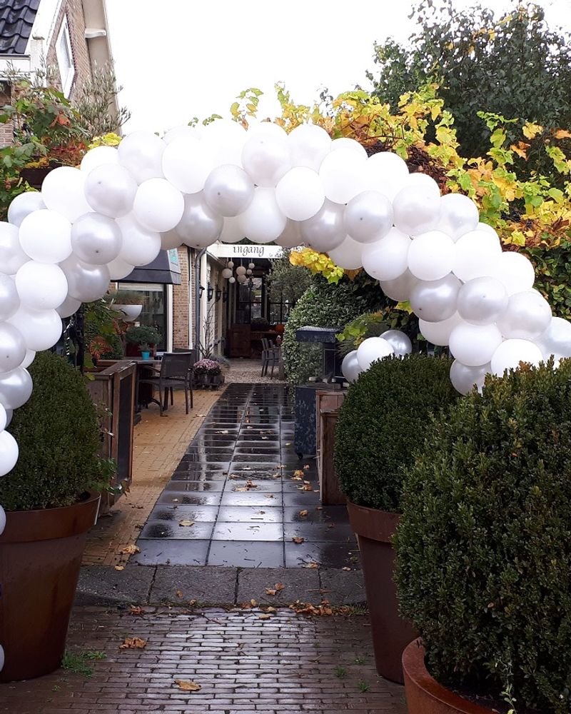 Witte ballonboog voor de entree van een restaurant