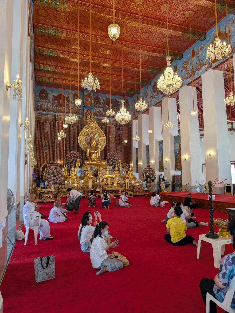 Buddhistischer Tempel - betende Menschen, kniend