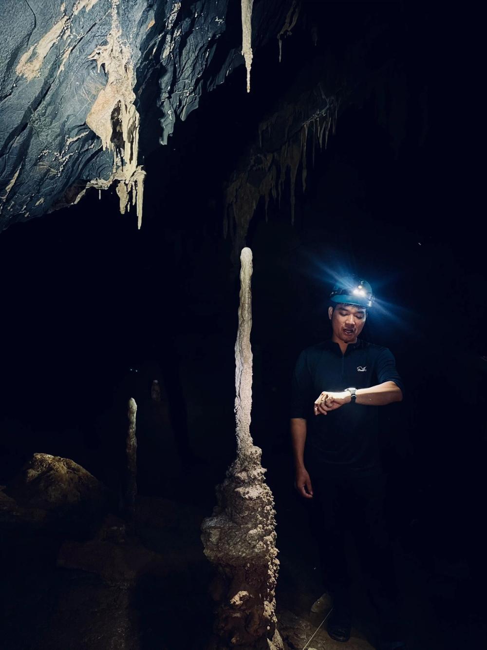 Tourguide neben Stalagmit