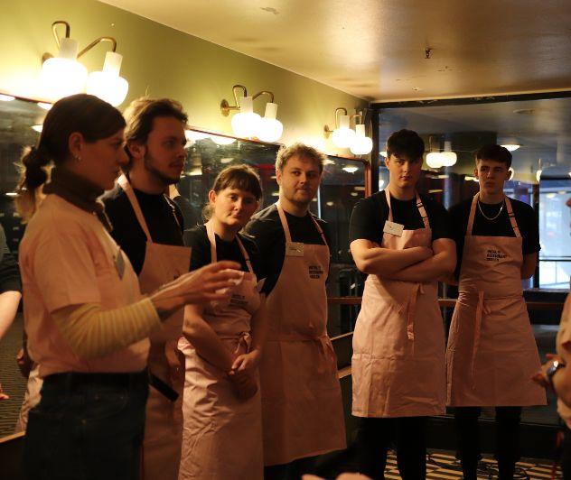 Kokkeelever gør klar unden de skal servere misosuppe til alle gæsterne, når de ankommer