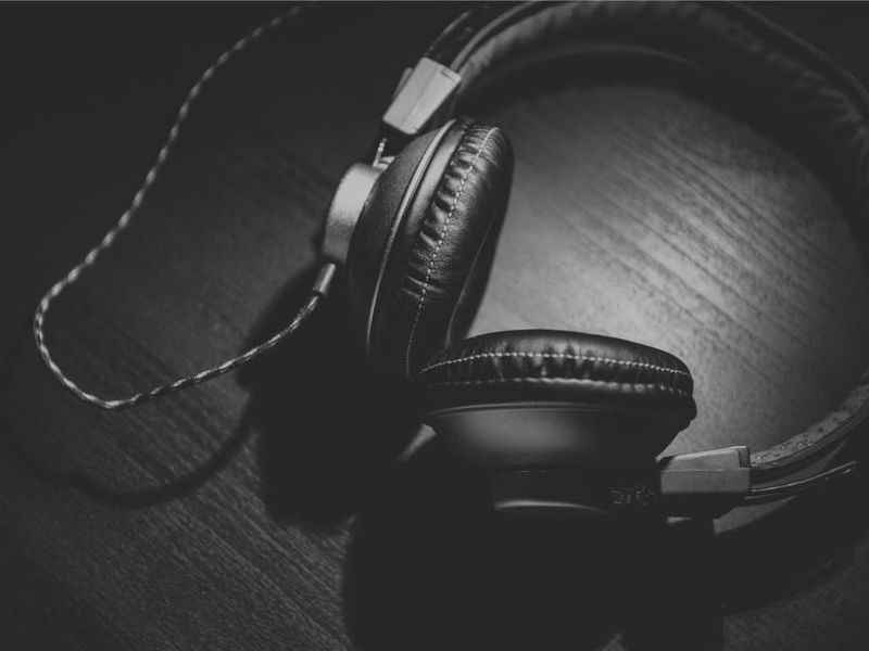 Un casque audio posé dans la pénombre, en noir et blanc