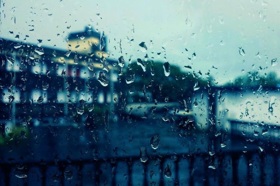 Des gouttes de pluie sur une vitre, le soir
