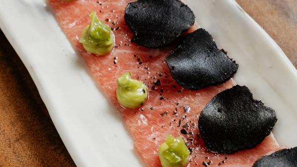 Carpaccio de ventresca Bluefin trufado con kizami, wasabi y crema de aguacate servido en Arko Sushi Restaurant Barcelona.
