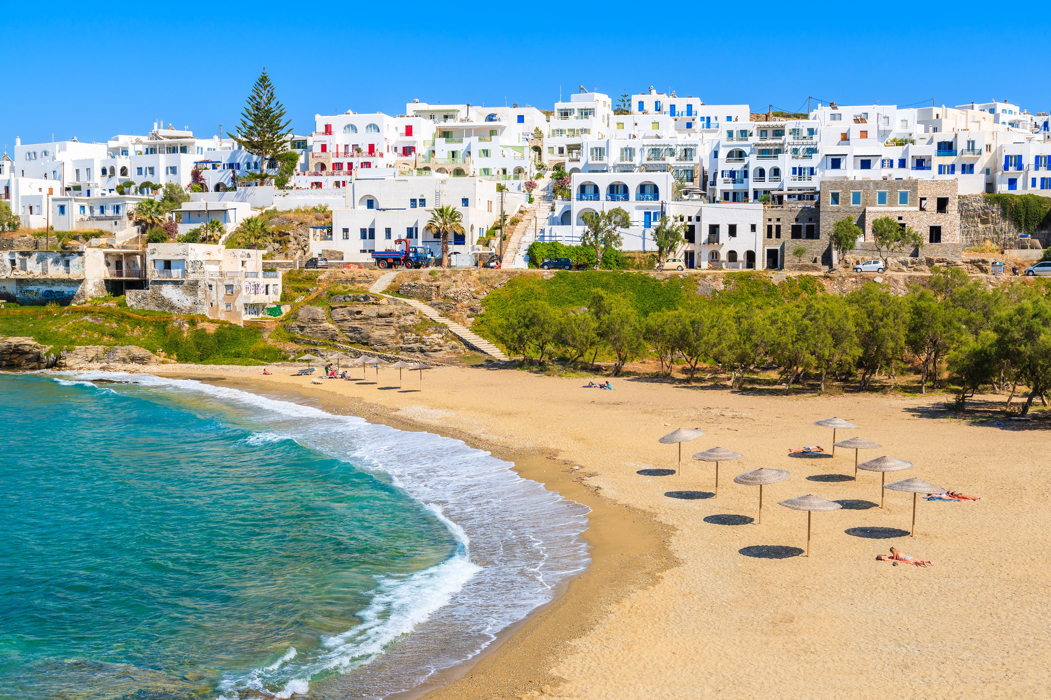 A beach in Paros, Greece, with white-washed buildings leading down to the beachfront