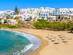 A beach in Paros, Greece, with white-washed buildings leading down to the beachfront