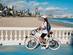Woman riding an electric bicycle looking over Levante beach in Benidorm