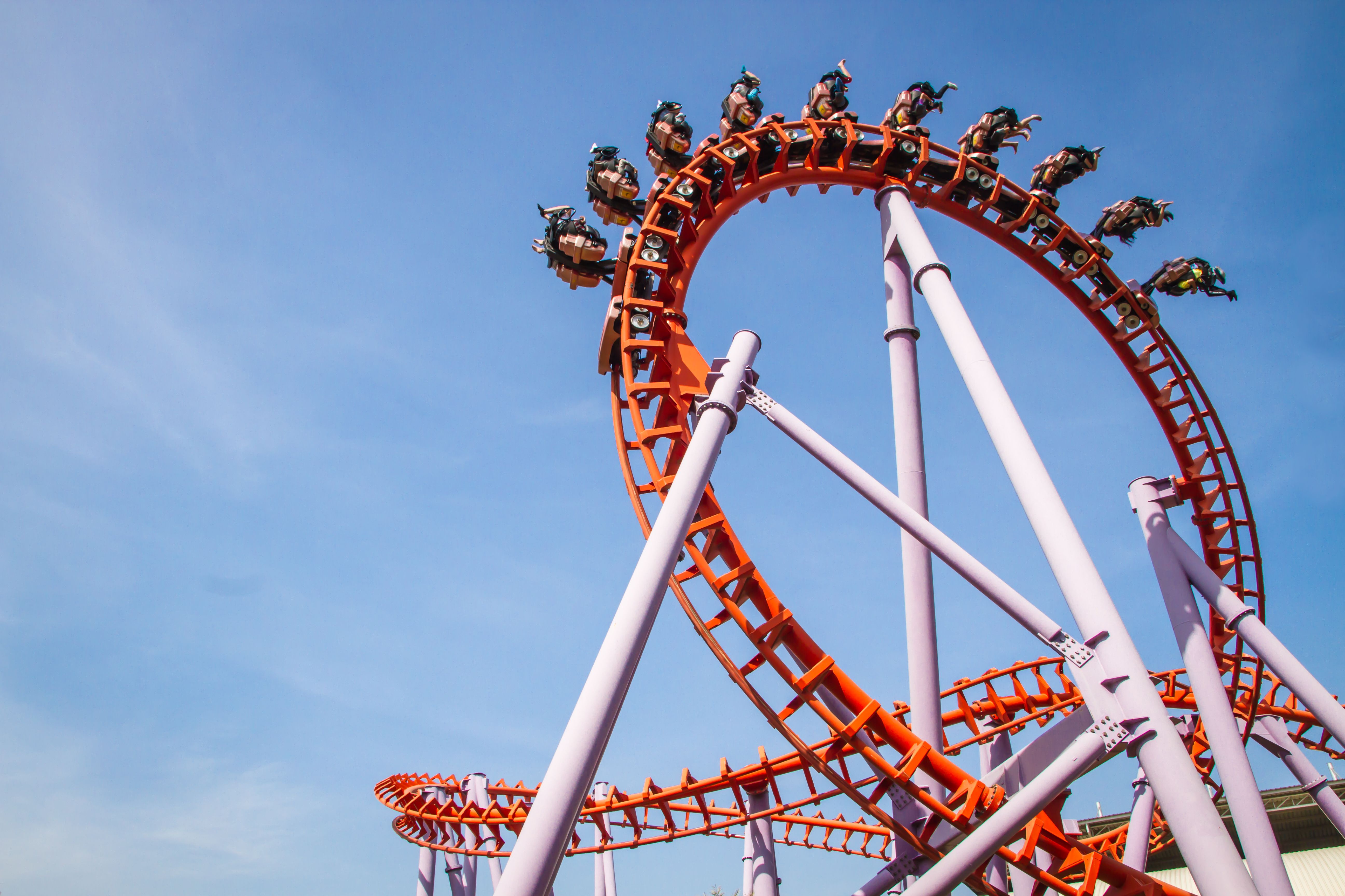 A close up of a rollercoaster ride with people upside down on a loop-the-loop