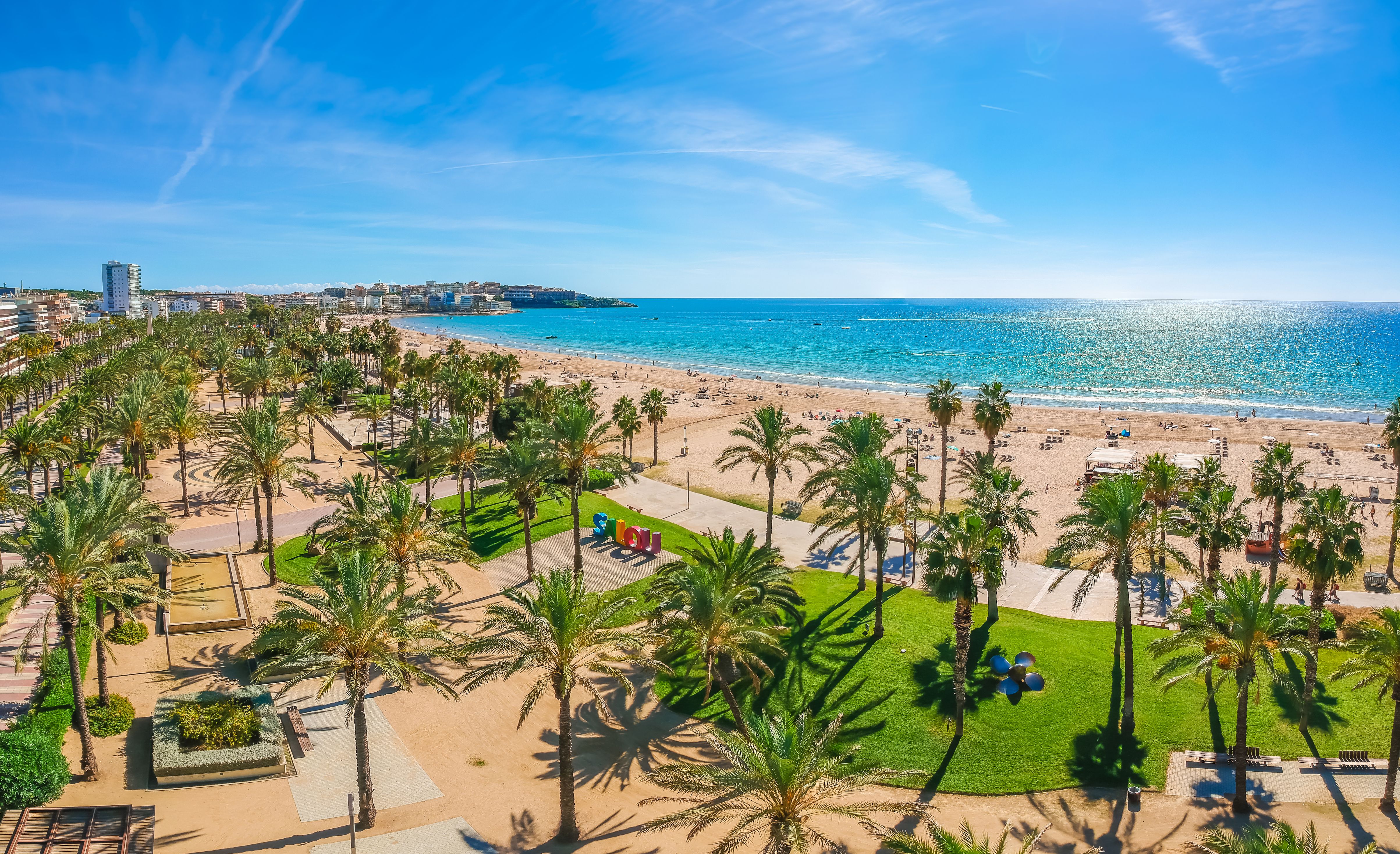 Beach, blue sea and palm trees in Salou city, Catalonia, Spain