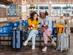 Two young female tourists looking at their phone while waiting for a train or a bus at the station.