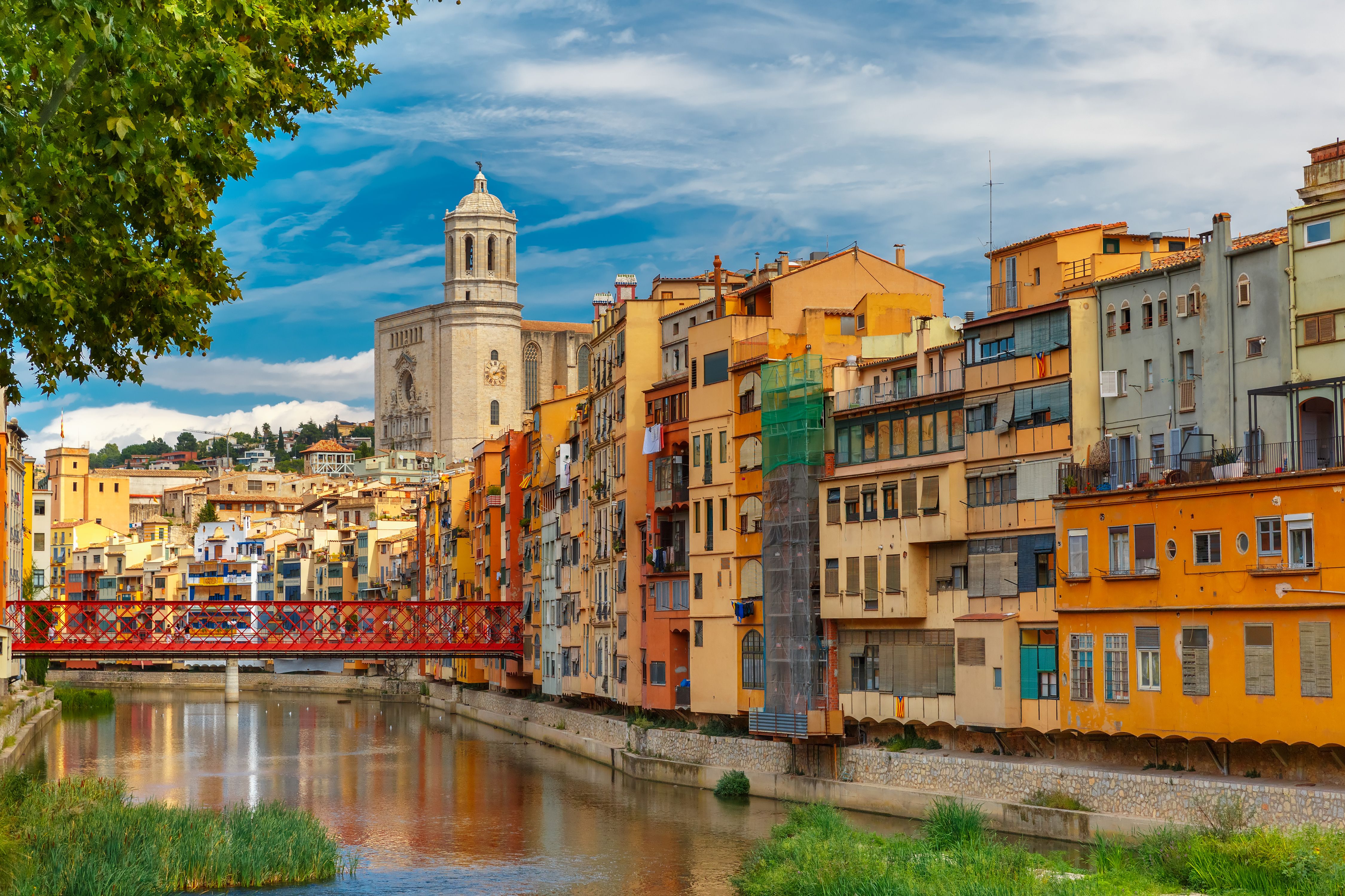 A view of colourful yellow and orange houses and the Eiffel Bridge on the riverfront in Girona, Spain