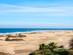 A view of the sand dunes and coastline at Maspalomas Beach in Gran Canaria