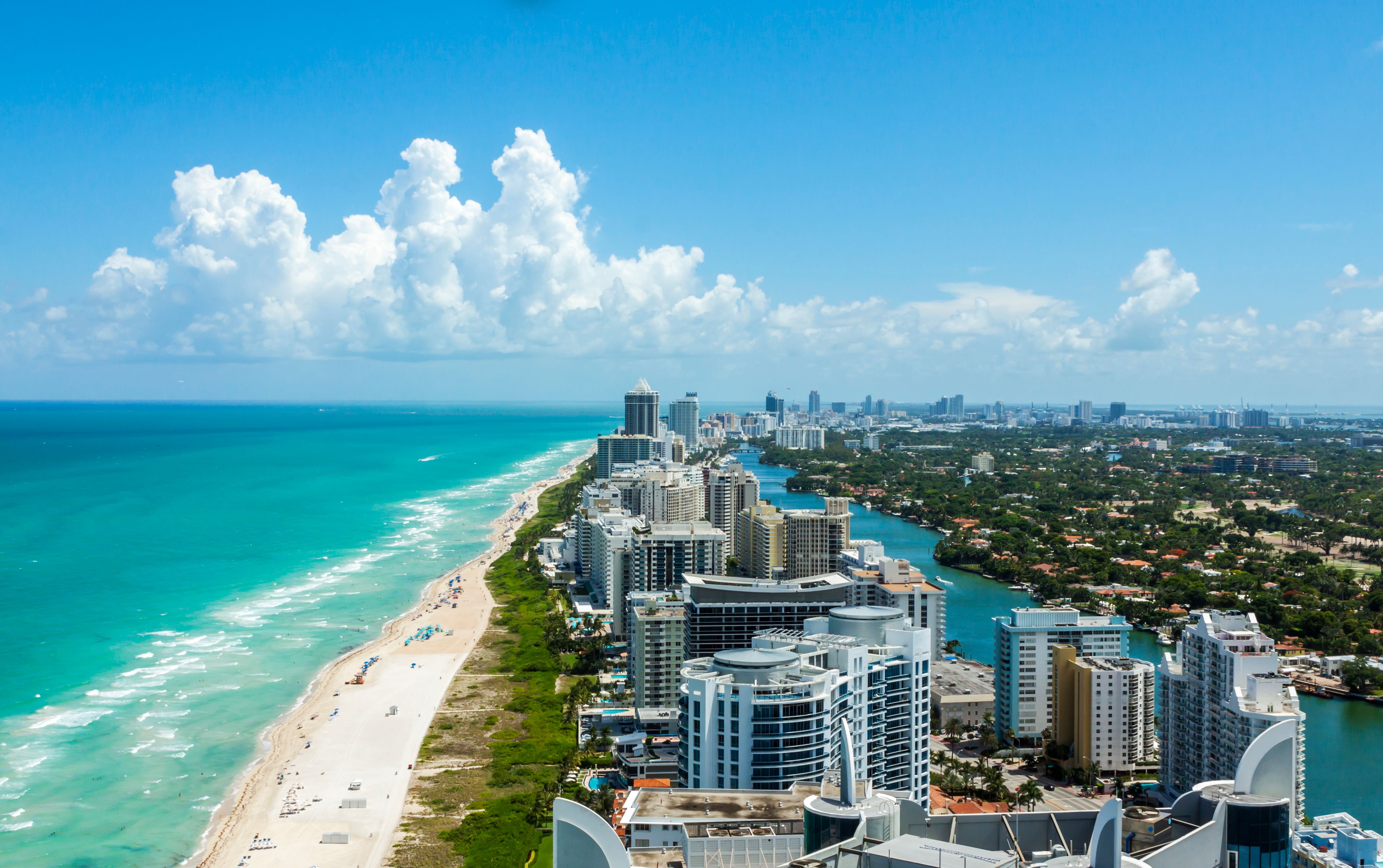 Full view of Miami beach on the left and the city on the right on a clear day with a blue sky
