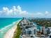 Full view of Miami beach on the left and the city on the right on a clear day with a blue sky