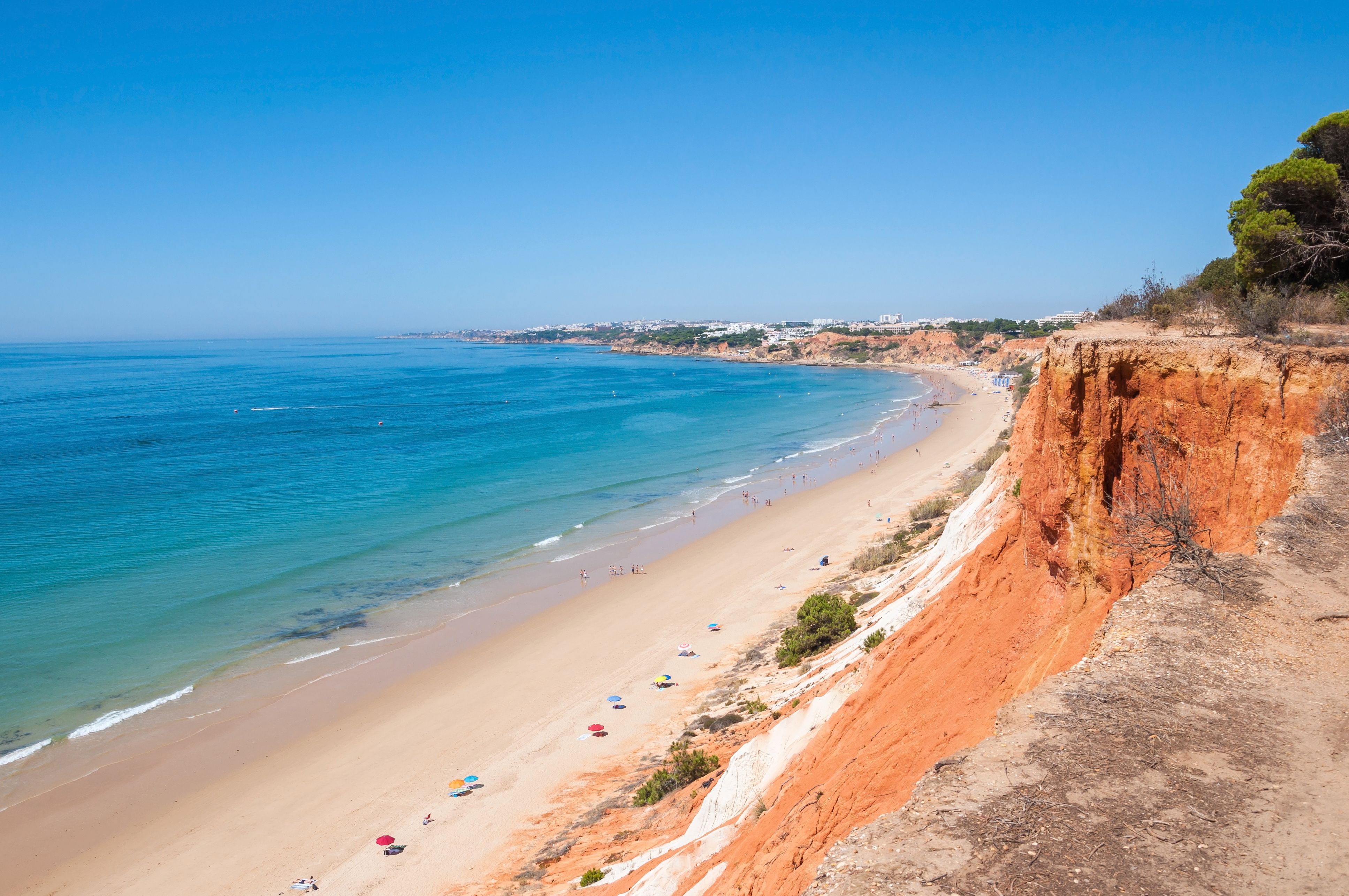 View across the rust-red cliffs and golden sand of Praia de Falesia